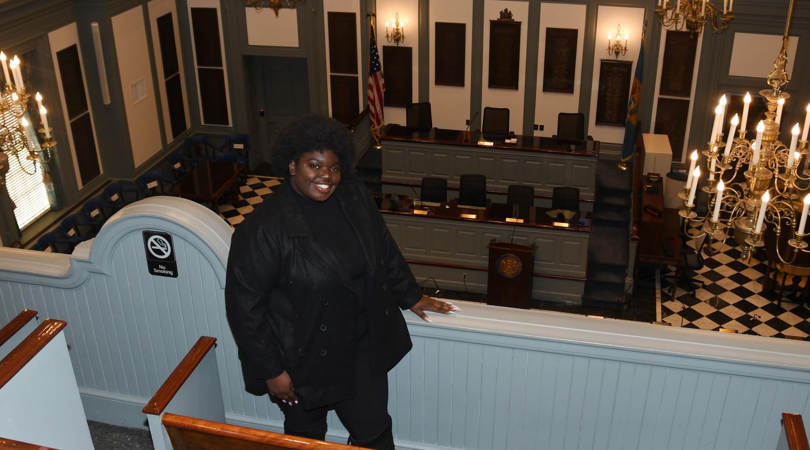 Adriante Carter stands above the Delaware House of Representatives chamber in Legislative Hall in Dover, where she will work represent the University as a Legislative Fellow during her final semester in the spring.