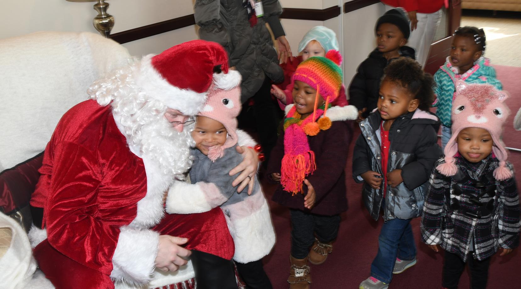 Santa Claus (portrayed by guess who?) greets the young ones of the Child Development Lab in the President's Office on Dec. 13.