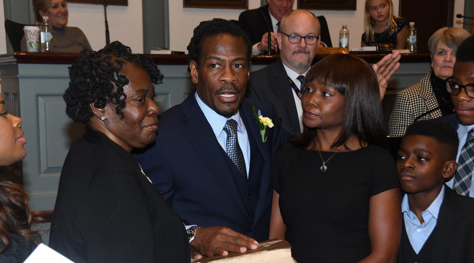 Newly elected Rep. Nnamdi Chukwuocha, surrounded by his family, is sworn in as a member of the Delaware House of Representatives by Delaware Supreme Court Justice James T. Vaughn, Jr. The new legislator's mother Mary Jones (l) holds the bible while his wife Chica stands to his right.