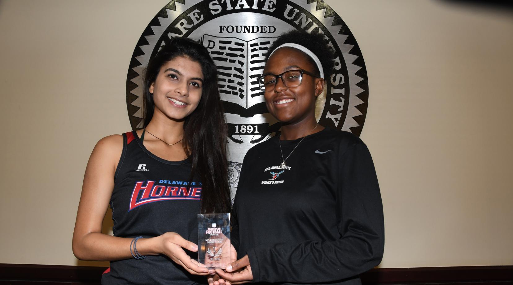 <p>(L-r) Aayushi Chouhan and Braxton Clark represented the University well as they were on the first and second place teams, respectively, in the Business Case Studies Competition at the recent NFL Careers in Football Forum held in Atlanta. The two are holding Ms. Chouhan's first-place trophy (Ms. Clark has already placed her second place trophy in her parent's home).</p>