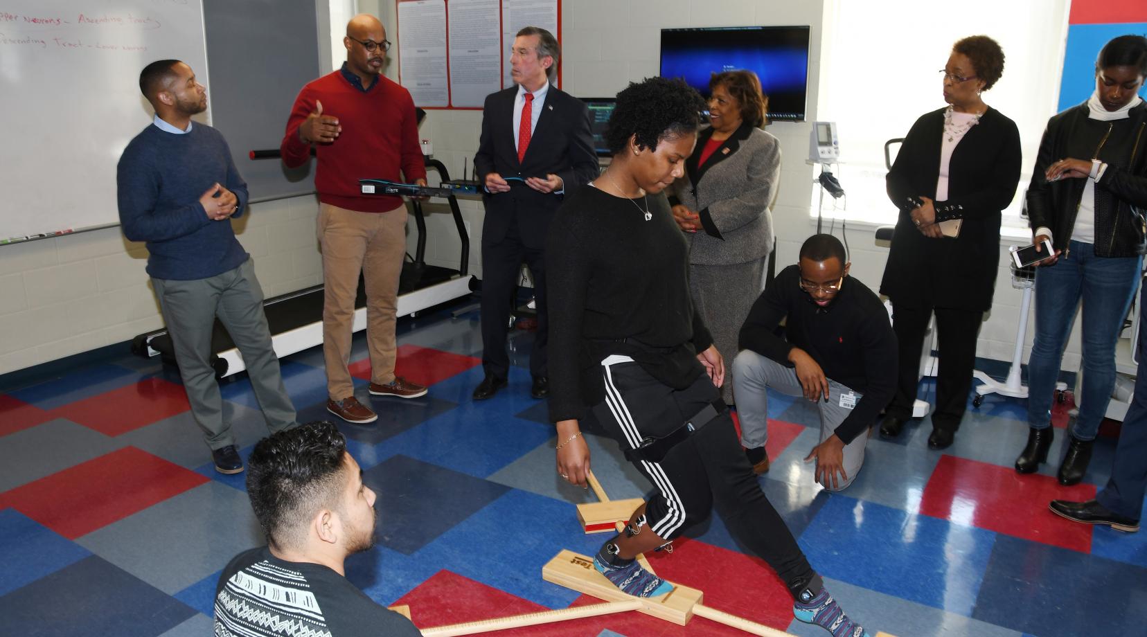 A kinesiology student does movements while electrodes measure electrical activity in her ankle muscles. This predictive injury analysis was part of a Feb. 5 demonstration presented (background l-r) by Dr. Chris Mason and Dr. Von Homer to Gov. John Carney, University President Wilma Mishoe and Dr. Marsha Horton, dean of the College of Health and Behavioral Sciences.