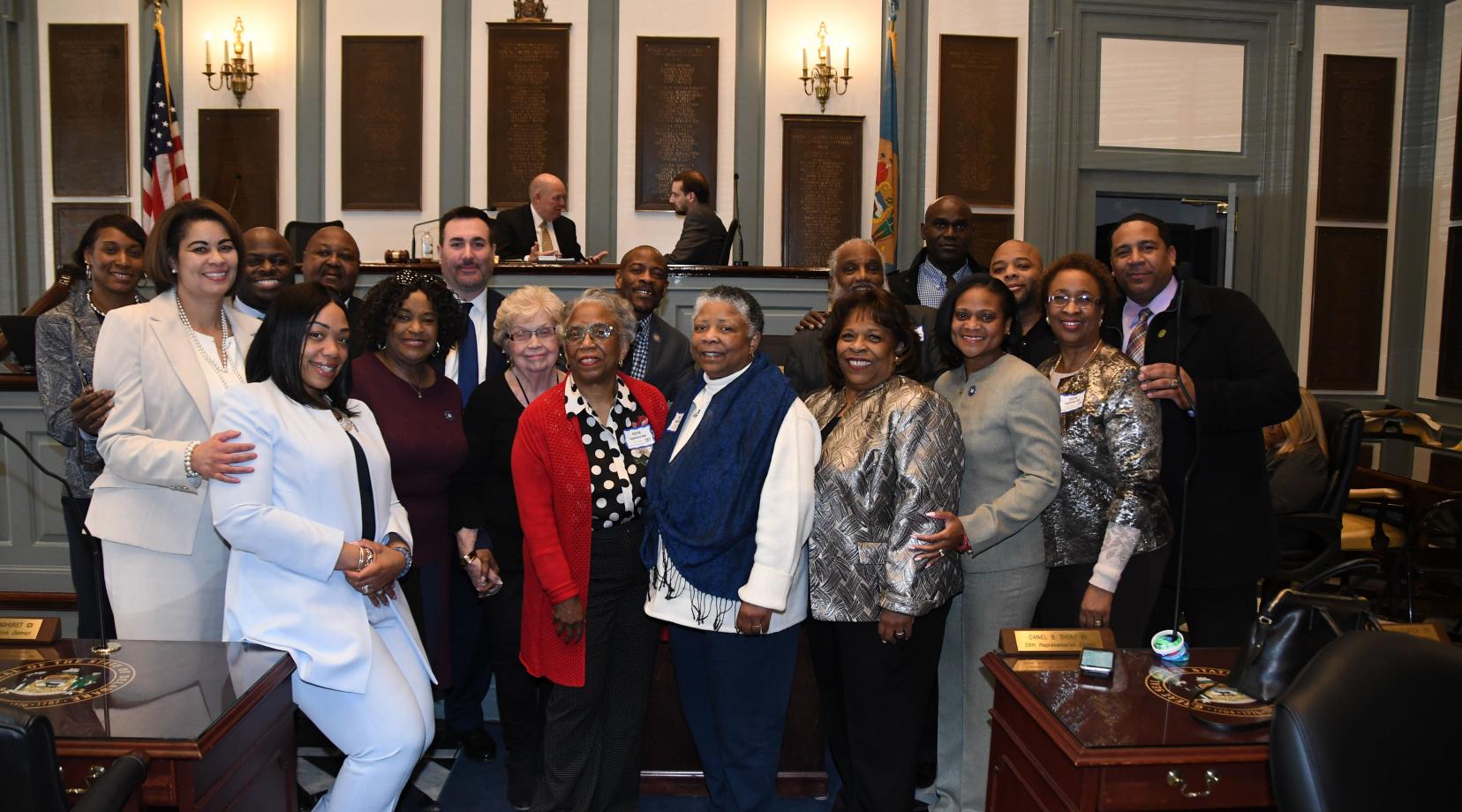 <p>The family of Hattie Mishoe (which include her daughters Bernellyn Carey in the center in red, and to her right Rev. Rita Paige and University President Wilma Mishoe) along with some of the House Joint Resolution No. 2 sponsors and friends celebrate the legislative expression honoring the former First Lady and the wife of then-Delaware State College President Luna I. Mishoe.</p>