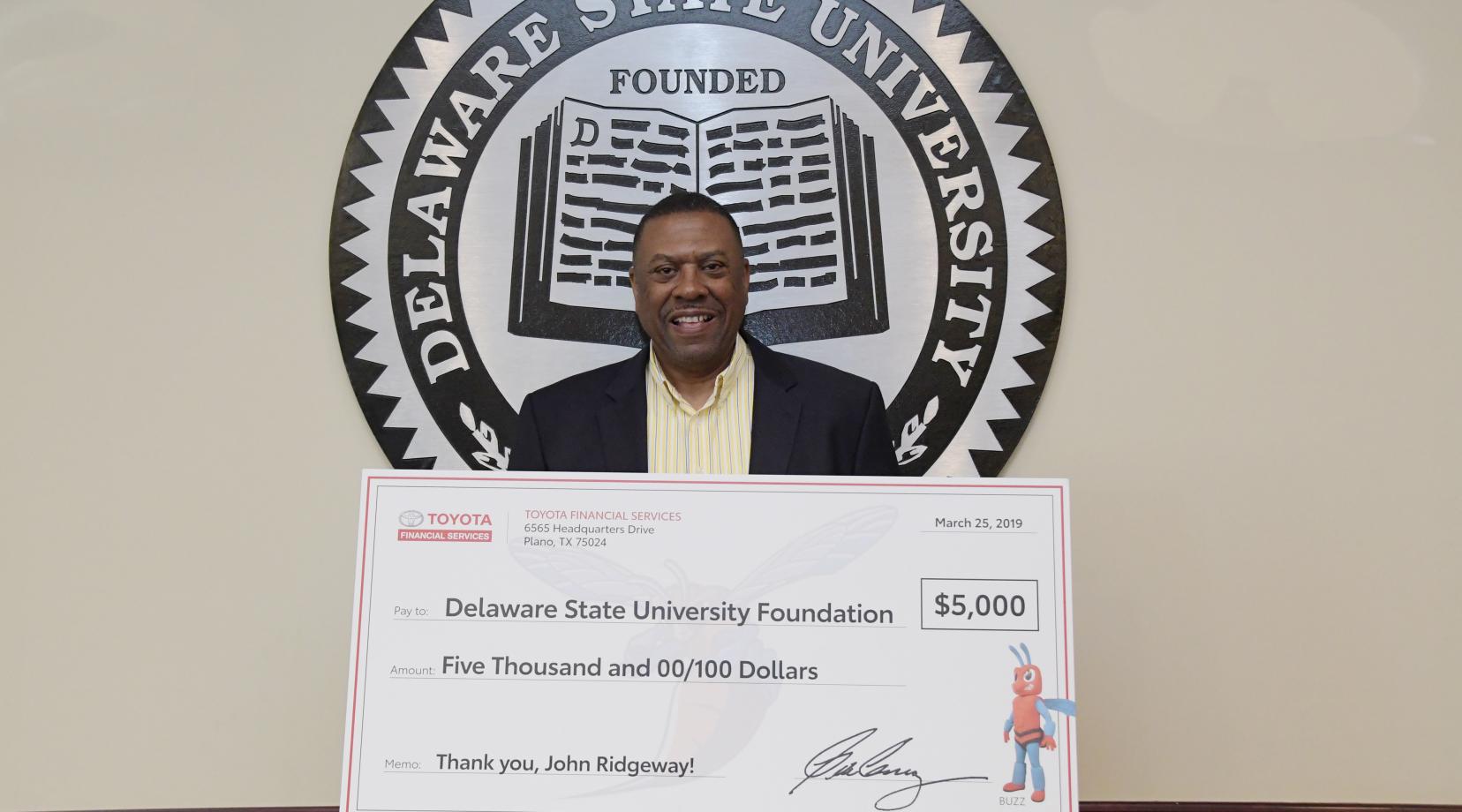 University Board of Trustees Vice Chair John Ridgeway shows a display check of a $5,000 gift presented as a donation by Toyota into an endowed scholarship he established with his wife Sherri. The donation was a retirement gift by Toyota; several other of his work colleague have also donated money into the endowment.