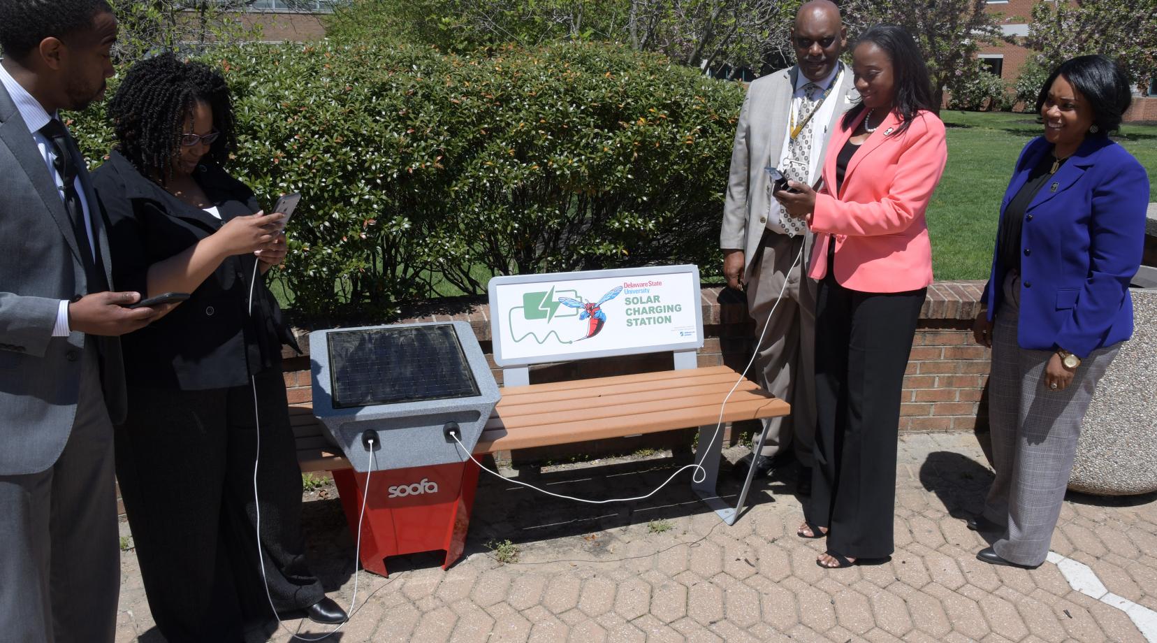 Some University employees try out one of the new solar benches installed outside of the William C. Jason Library and the Mishoe Science Center.