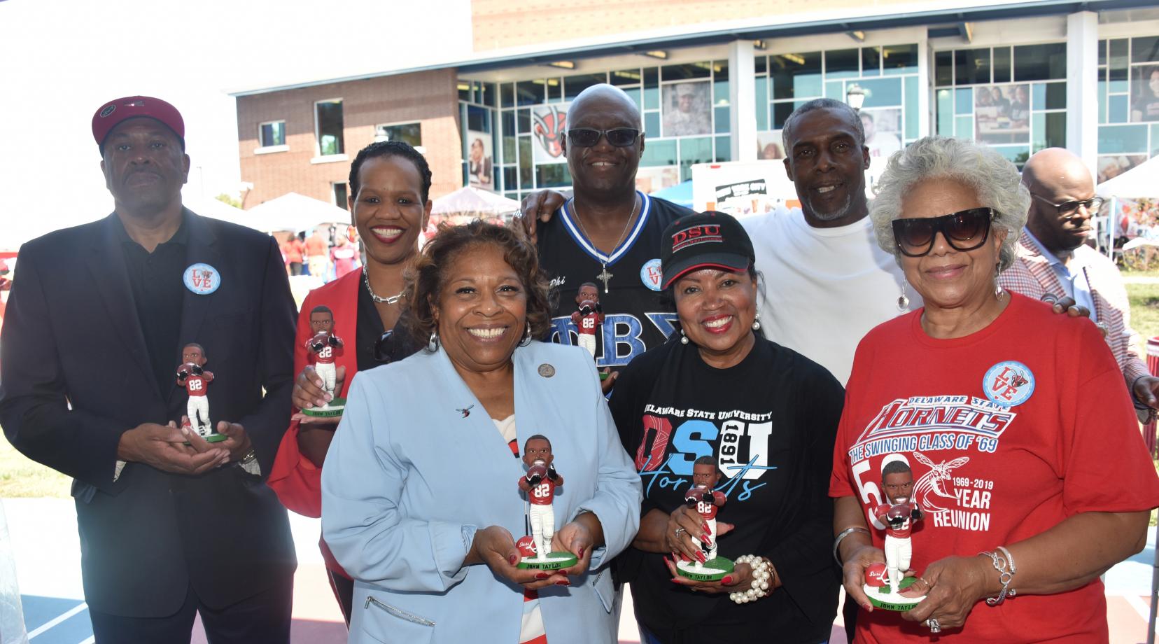 Hornet football alumnus and former NFL star John Taylor (2nd from the right) presents members of the University Board of Trustees and Dr. Wilma Mishoe with a signed bobble head likeness of himself.