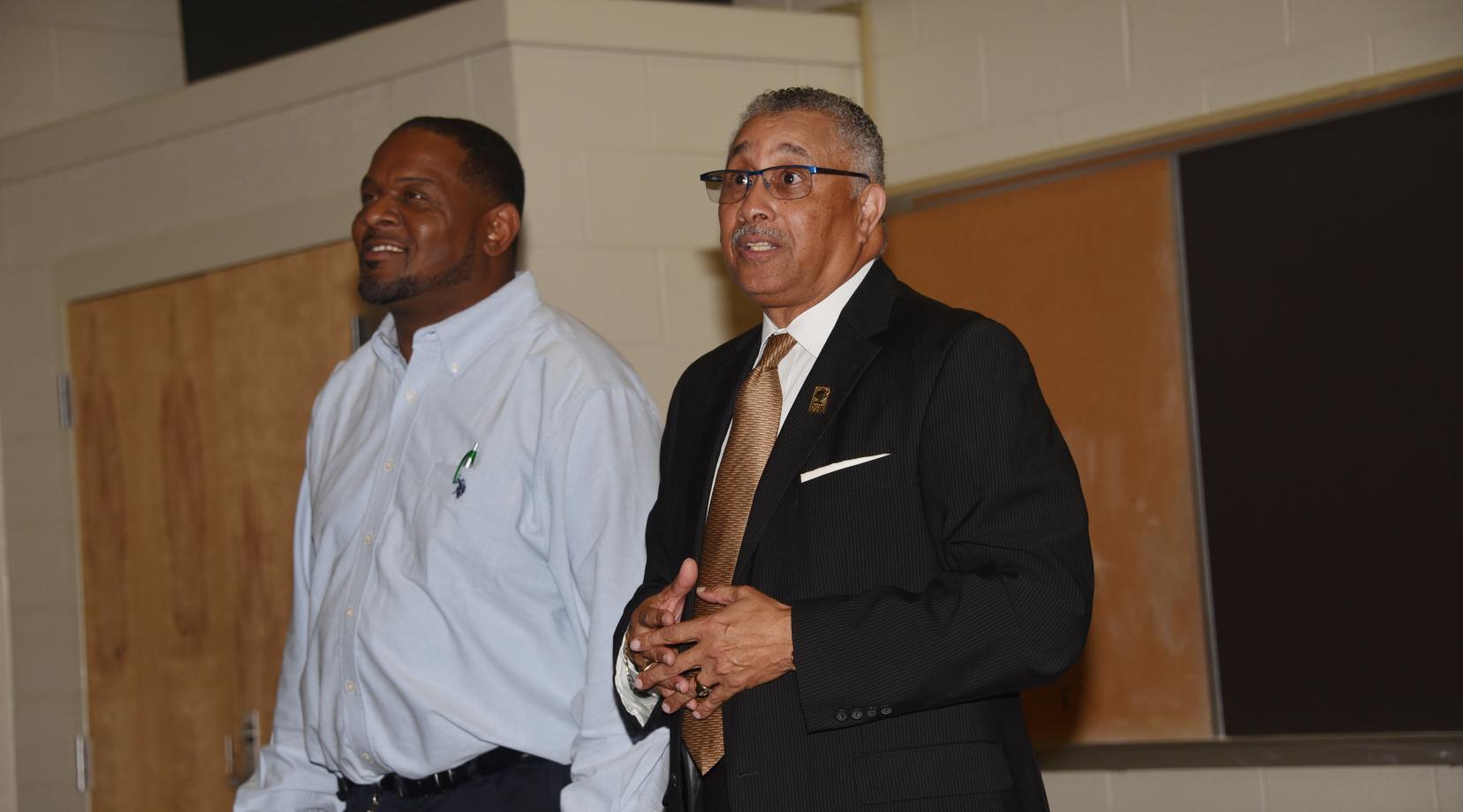 Herman Woods, the new Associate Vice President of Facilities Management, Planning and Construction, introduces himself to the custodial staff as Bernard Pratt, Senior Director of Plant Maintenance stands alongside.