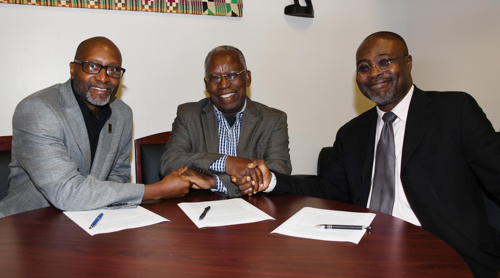 (L-r) Ezrah Aharone, director of the University's Center for Global Africa; Kojo Yankah, founder of the African University College of Communications in Ghana; and Dr. Akwasi Osei, associate dean of the College of Humanities, Education and Social Sciences, shake hands after signing a collaboration agreement between the two institutions.