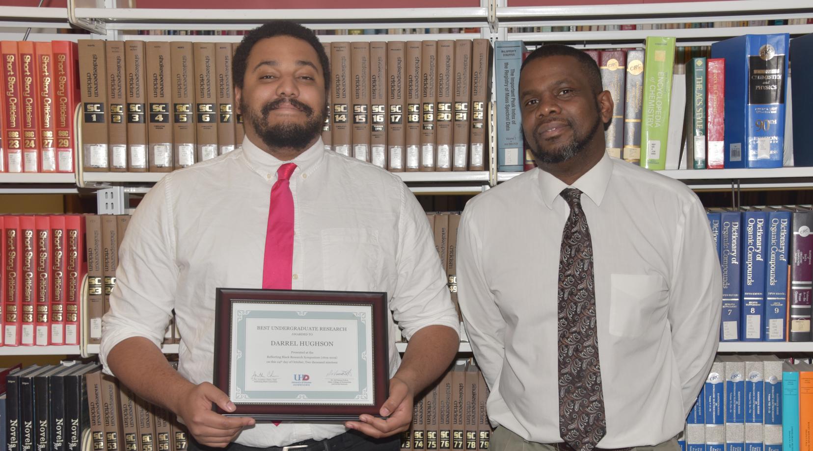 Darrell Hughson,(r), a junior English major, recently took the $500 first-place in a research presentation competition in a national symposium in Houston, Texas.