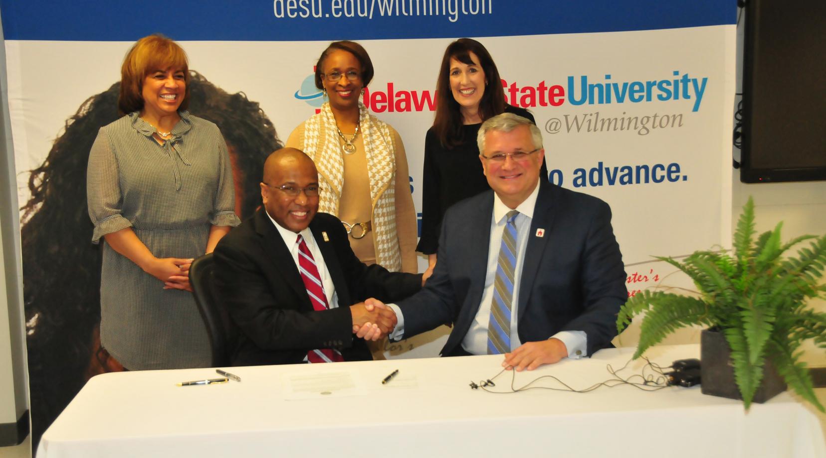 DSU President Harry L. Williams shakes hands with Red Clay School District Superintendent Merv Daugherty after signing an agreement to offer IT courses to high school students at DSU@Wilmington.