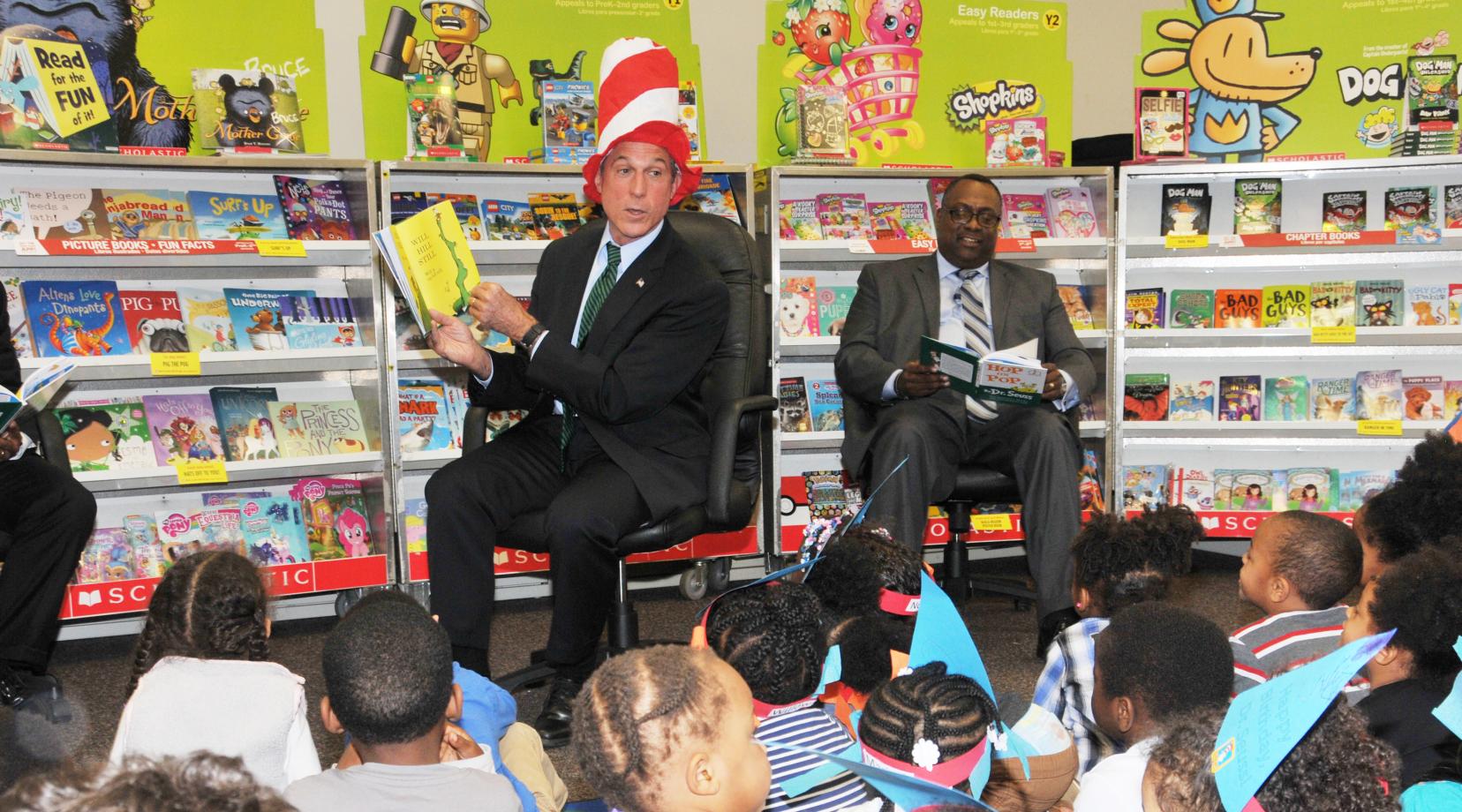 Gov. John Carney reads to the children, while Tyrone James of the United Way of Del. also reads along.
