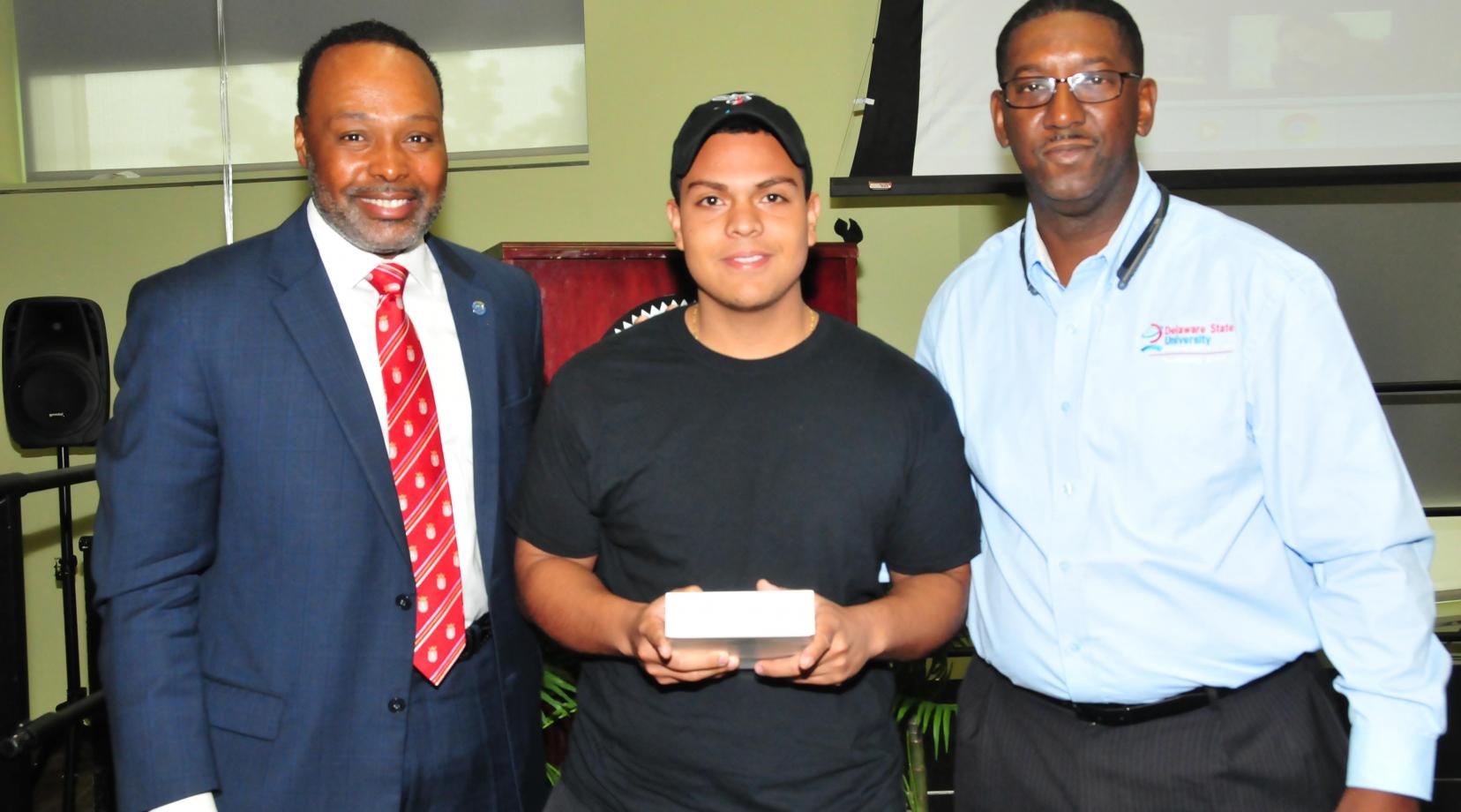 Kevin Coque Alarcon, a freshman mass communications major (center), won a digital drawing and took home an iPad Mini. Standing with him are keynote speaker James Collins (l) and DSU CIO Darrell McMillon.