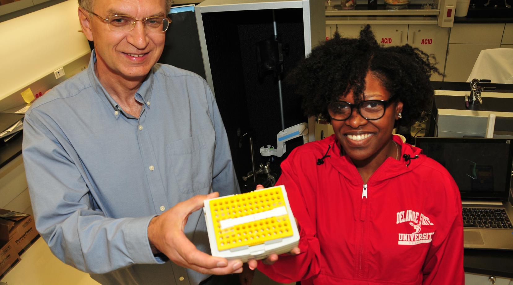 (L-r) Dr. Yuri Markushin, DSU physics researcher, and junior physics major Simone Johnson hold a pet strip invented here at DSU to help dog owners diagnose certain diseases in their pet and thereby save veterinarian costs.
