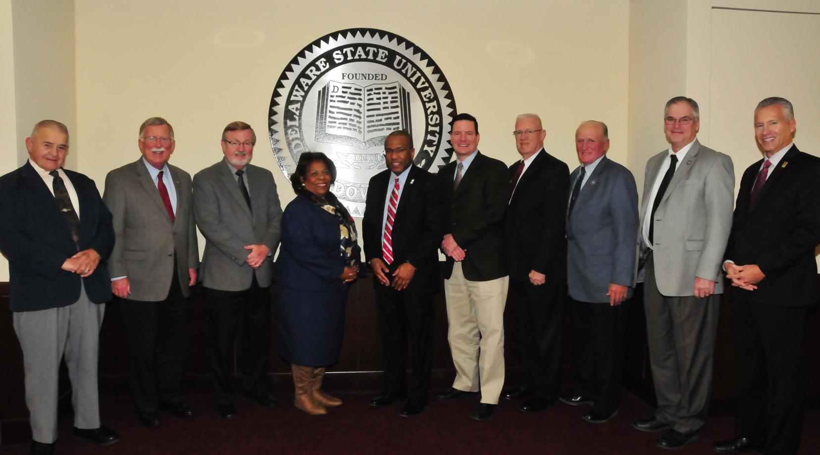 Dr. Harry L. Williams, joined by DSU Board of Trustees Chairwoman Dr. Wilma Mishoe, posed with a group of Kent County state legislators who held their final meeting with the outgoing DSU president on Dec. 12.