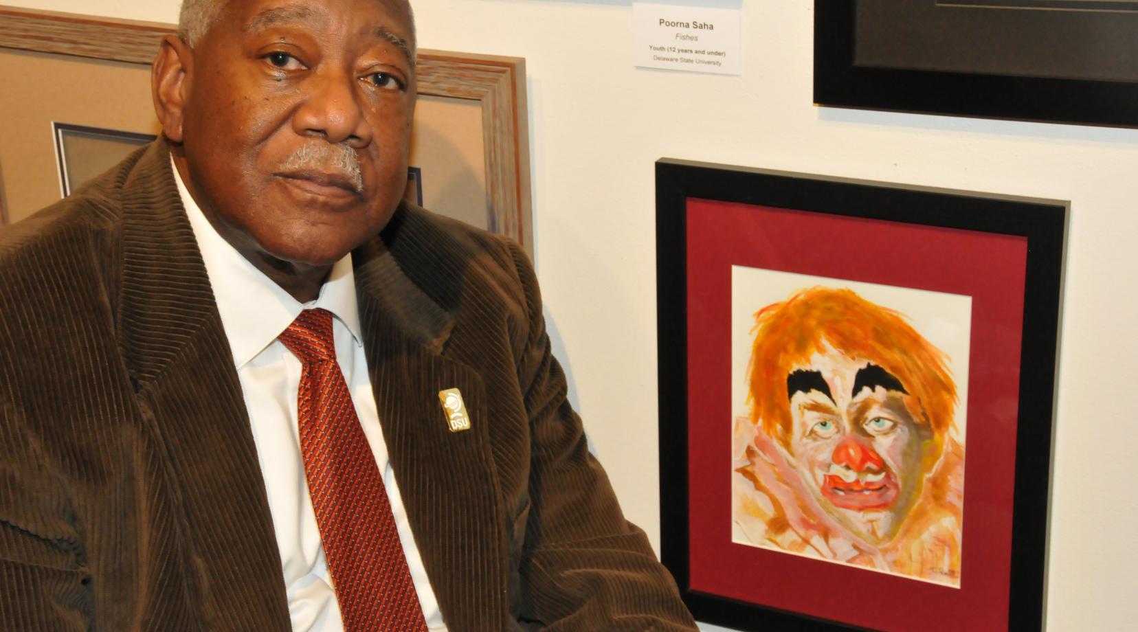 Bryant T. Bell with his artwork entitled "Barnum and Bailey Circus," one of the more than 200 works on display in the State Employee Exhibition in the Arts Center/Gallery on campus.