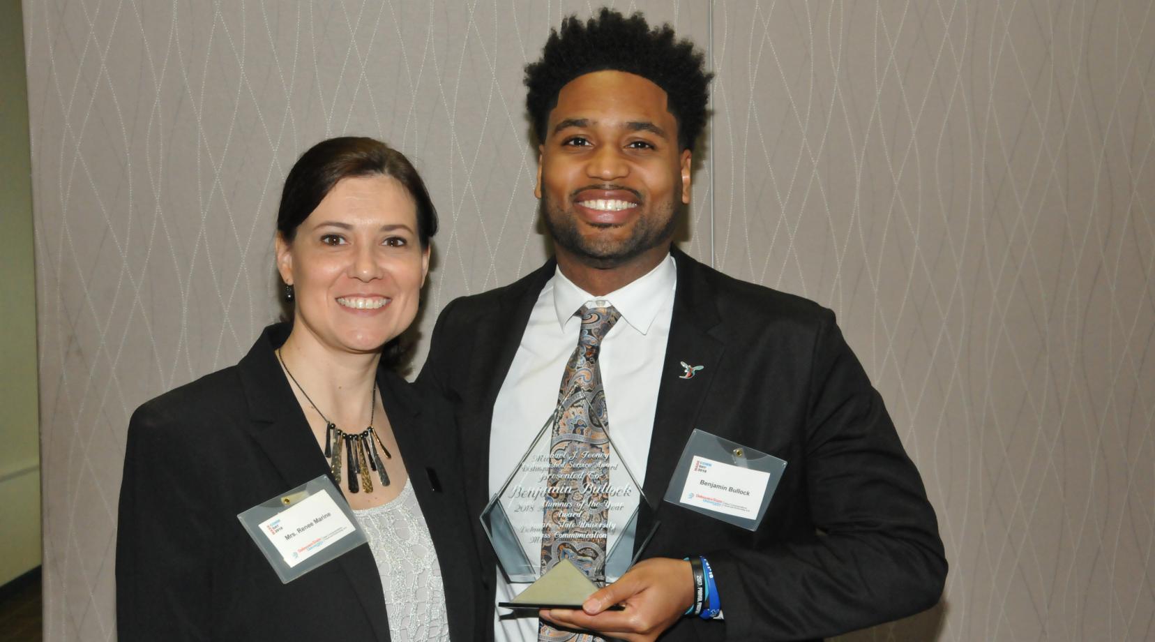 <p>Ben Bullock, DSU Mass Comm Class of 2010, receives the Michael J. Feeney Outstanding Alumni Award from presenter Renee Marine, Mass Comm program coordinator.</p>