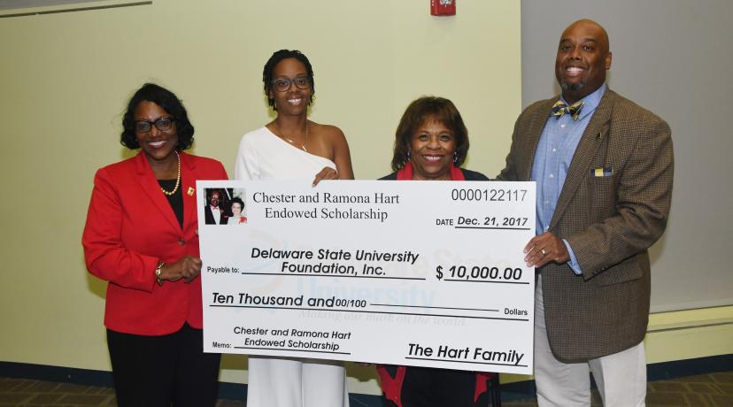 <p>Holding a display check for the newly established Chester and Ramona Hart Endowed Scholarship are (l-r) Dr. Vita Pickrum, Vice President of Institutional Advancement, Dana Hart-Raynor, University President Wilma Mishoe and Eric Hart.</p>