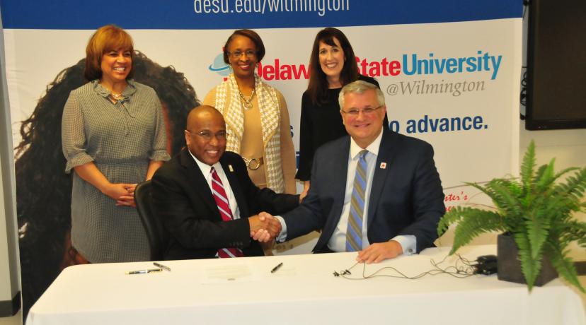 <p>DSU President Harry L. Williams shakes hands with Red Clay School District Superintendent Merv Daugherty after signing an agreement to offer IT courses to high school students at <a href="mailto:DSU@Wilmington">DSU@Wilmington</a>.</p>