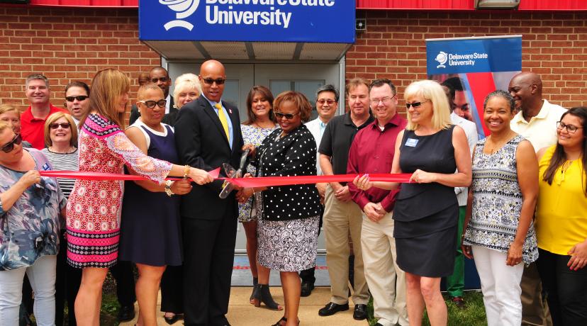 <p>DSU Board of Trustees member Roy Roper and DSU Chief Financial Officer Teresa Hardee join officials of the New Castle County Chamber of Commerce for a ribbon cutting ceremony at the <a href="mailto:DSU@Wilmington">DSU@Wilmington</a> location in recognition of its educational contribution to Northern Delaware.</p>